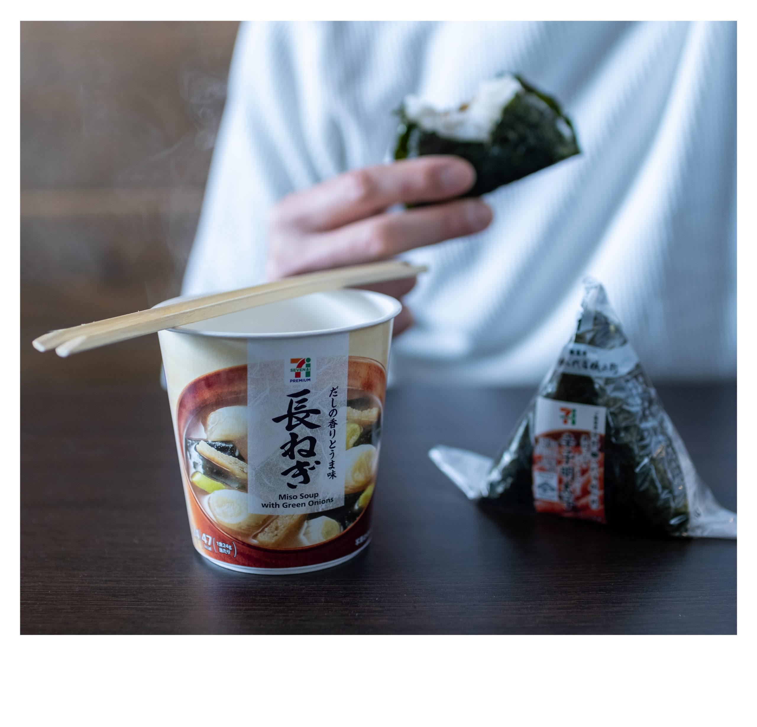 Japanese breakfast: A convenience store Onigiri and a cup of instant miso soup on a wooden table