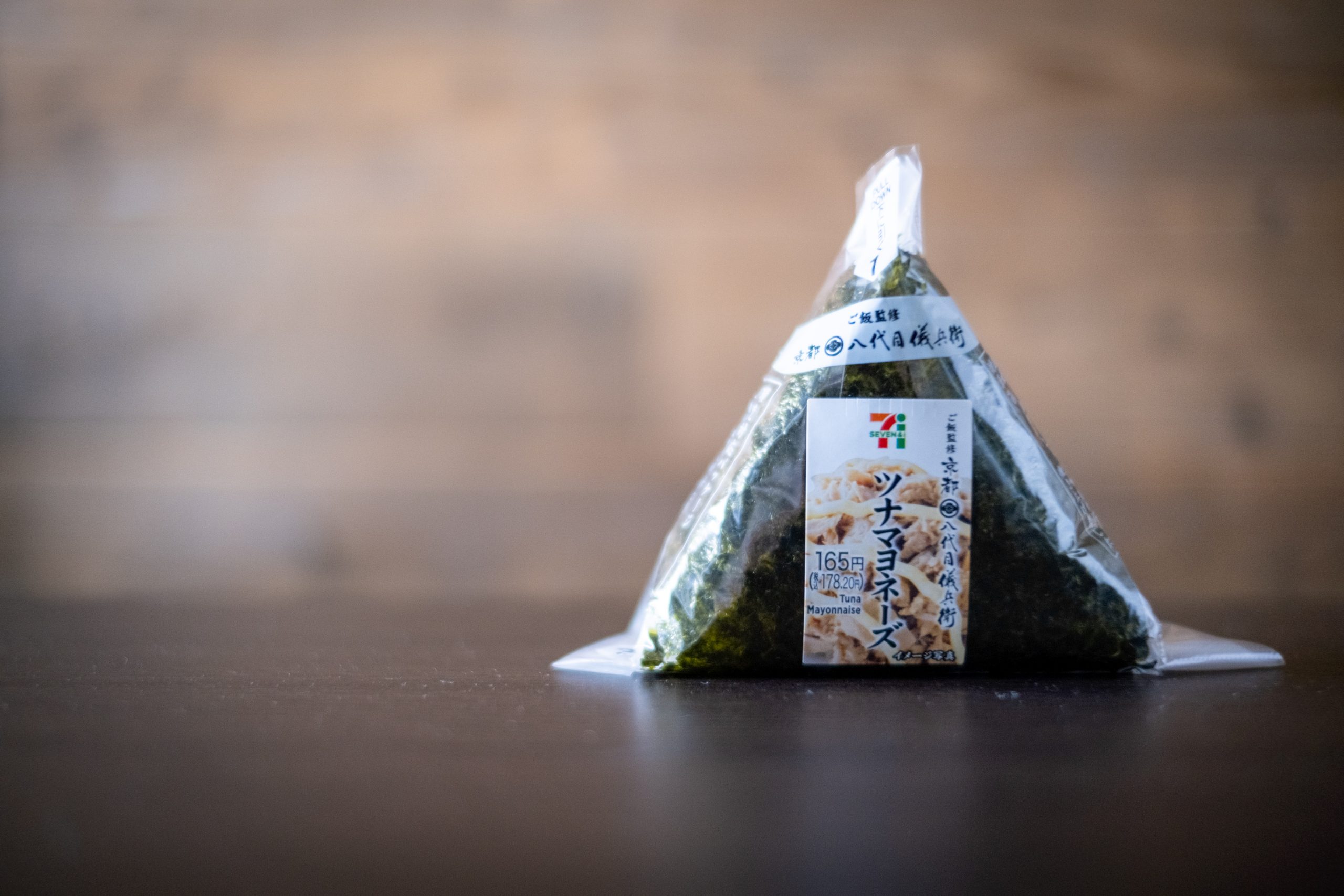 Japanese breakfast: A convenience store Onigiri and a cup of instant miso soup on a wooden table